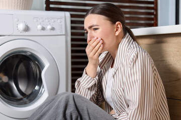 Young woman suffering from nausea in bathroom