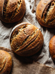 Freshly baked artisan bread loaves on cloth background with natural light