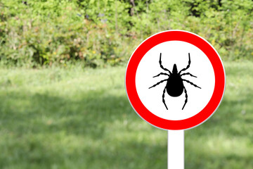 Warning sign marking habitat of ticks in nature