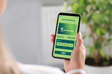 Online payment. Woman using banking app on smartphone indoors, closeup