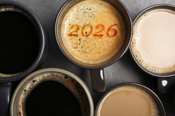 Hello New 2026 Year. Cup of coffee with numbers among others on grey table, top view