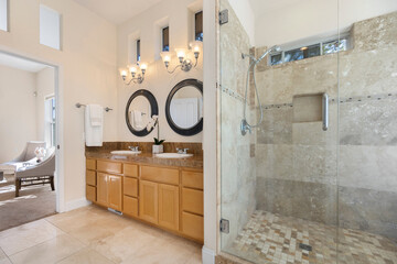 A spacious bathroom featuring two sinks alongside a walkin shower