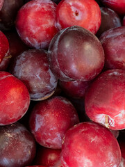 Close up of fresh ripe red and purple plums background