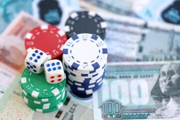 Egyptian pound currency money bills and casino chips with dices. The concept of gambling and poker casino games