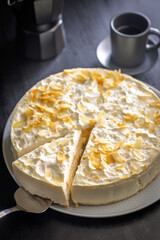 Sweet creamy cake on plate on black table.