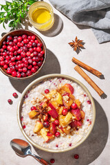 Overnight oatmeal with apple, cranberry, honey and cinnamon in a plate on a light background
