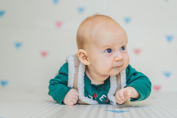 Adorable baby dressed in a Christmas sweater, jeans, and a warm furry vest, ready for winter holidays. Festive baby fashion and cozy holiday moments concept
