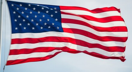 Fototapeta premium Waving american flag against blue sky on a windy day