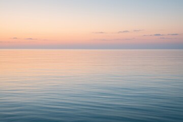 Obraz premium Dreamy sunrise seascape with glowing horizon gentle waves and pastel blue open sky
