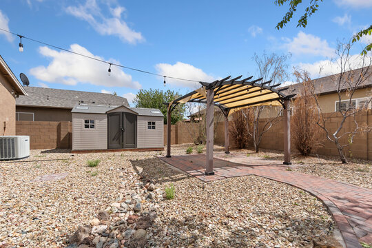 A serene backyard featuring a charming pergola along with a shed