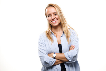 Businesswoman in light blue shirt smiles confidently while standing against a white background,...