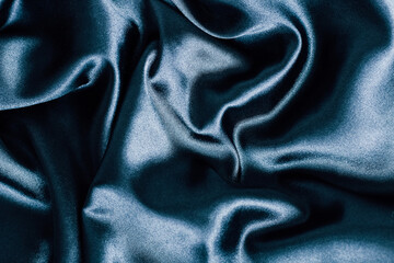 Elegant deep blue satin fabric draped with soft folds and texture