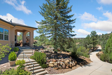 A house with stairs is surrounded by rocks and trees