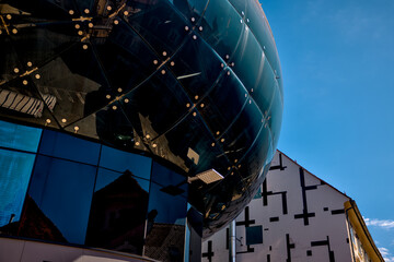 Graz, Austria – July 22, 2025: A close-up of the futuristic facade of Kunsthaus Graz, the city’s iconic contemporary art museum, with its distinctive organic form and reflective glass surface.
