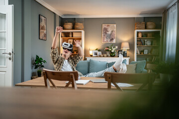 Young man enjoying virtual reality gaming experience at home