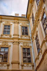 Obraz premium Graz, Austria – July 22, 2025: Historic residential buildings and storefronts with stucco façades and traditional wooden windows in the Old Town district of Graz under a clear summer sky. 