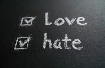 Fototapeta premium Chalkboard with two options love or hate. Both are selected with tick sign. Choose love concept for social media posts. Choice between emotions in relationships decision with chalk text.