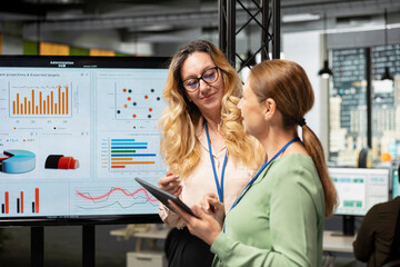 Female business team in a briefing session symbolizes efficiency in modern office, reviewing analytics in order to refine company vision and objectives. Professionalism and corporate feminism.