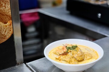 A bowl of Nyonya prawn laksa on the kitchen counter of Old Nyonya, a hawker stall at Maxwell Food Centre - downtown Singapore, near Chinatown