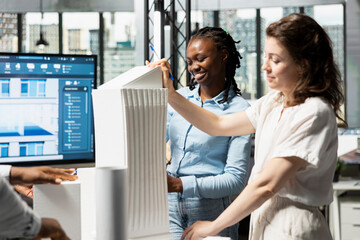 Real estate engineers work together on architectural 3D models details, collaborating on residential project strategy for a modern construction. Urban development for housing and infrastructure.