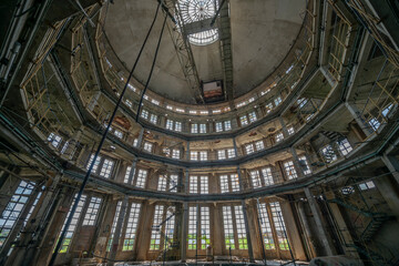 Obraz premium Abandoned distillery tower in Italy – circular industrial building with glass dome, steel beams, panoramic windows, decaying factory interior, urban exploration, post-industrial architecture
