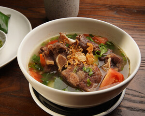 Traditional Indonesian Oxtail Soup or Sop Buntut Served in White Bowl