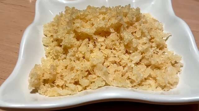 Tanuki served on a white plate. Tanuki is crunchy tempura flakes for sushi.