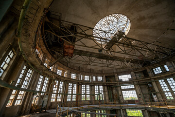 Obraz premium Abandoned distillery tower in Italy – circular industrial building with glass dome, steel beams, panoramic windows, decaying factory interior, urban exploration, post-industrial architecture