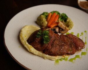 Grilled Beef Steak with Mashed Potatoes and Steamed Vegetables on Ceramic Plate