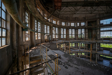 Abandoned distillery tower in Italy – circular industrial building with glass dome, steel beams, panoramic windows, decaying factory interior, urban exploration, post-industrial architecture