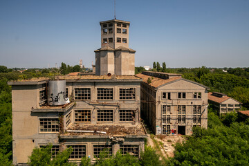 Fototapeta premium Abandoned distillery tower in Italy – circular industrial building with glass dome, steel beams, panoramic windows, decaying factory interior, urban exploration, post-industrial architecture