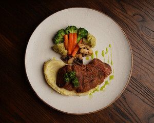 Grilled Beef Steak with Mashed Potatoes and Steamed Vegetables on Ceramic Plate