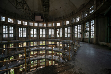 Fototapeta premium Abandoned distillery tower in Italy – circular industrial building with glass dome, steel beams, panoramic windows, decaying factory interior, urban exploration, post-industrial architecture