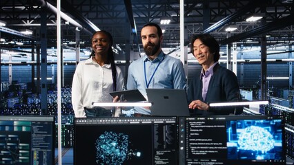 Fototapeta premium Happy data center colleagues collaborating on neural network software development. Cheerful teamworking server hub coworkers implementing machine learning technology in workplace, camera A