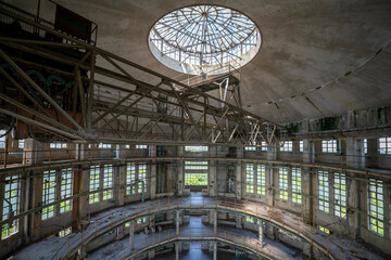 Abandoned distillery tower in Italy – circular industrial building with glass dome, steel beams, panoramic windows, decaying factory interior, urban exploration, post-industrial architecture