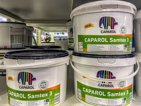 Riga, Latvia - October 30, 2025 Caparol Colorful paint buckets labeled Caparol Samtex 3 stacked on a shelf in Depo store, showcasing vibrant branding and product design for home improvement projects