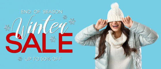 Young woman in winter clothes on blue background