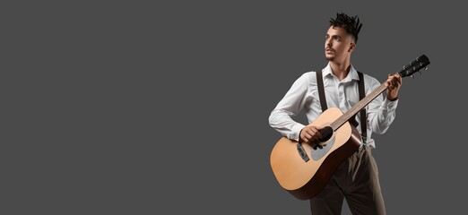 Young man with dreadlocks playing guitar on grey background with space for text