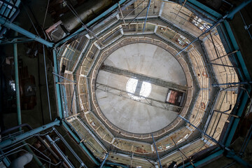 Abandoned distillery tower in Italy – circular industrial building with glass dome, steel beams, panoramic windows, decaying factory interior, urban exploration, post-industrial architecture