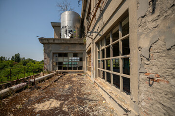 Abandoned distillery tower in Italy – circular industrial building with glass dome, steel beams, panoramic windows, decaying factory interior, urban exploration, post-industrial architecture