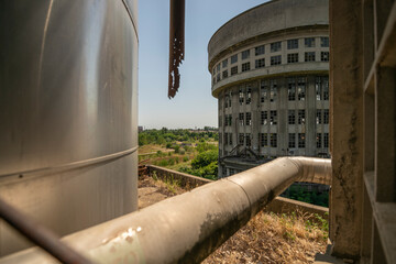 Abandoned distillery tower in Italy – circular industrial building with glass dome, steel beams, panoramic windows, decaying factory interior, urban exploration, post-industrial architecture