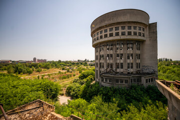 Abandoned distillery tower in Italy – circular industrial building with glass dome, steel beams, panoramic windows, decaying factory interior, urban exploration, post-industrial architecture