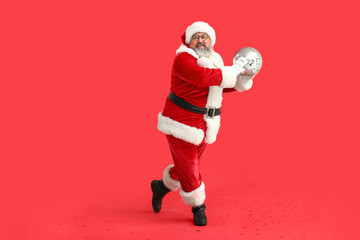 Dancing Santa Claus with disco ball on red background