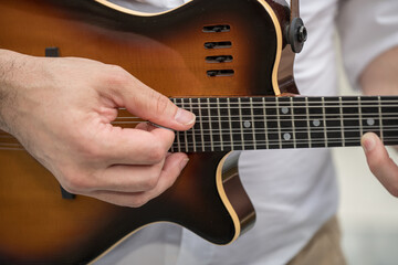 Fototapeta premium a person playing a Godin A8 electric mandolin. This is an 8-string mandolin,