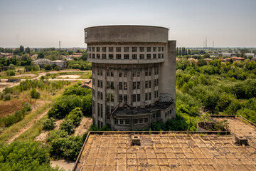 Abandoned distillery tower in Italy – circular industrial building with glass dome, steel beams, panoramic windows, decaying factory interior, urban exploration, post-industrial architecture