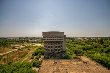 Abandoned distillery tower in Italy – circular industrial building with glass dome, steel beams, panoramic windows, decaying factory interior, urban exploration, post-industrial architecture