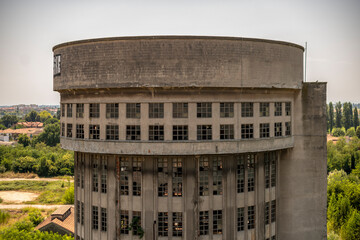 Abandoned distillery tower in Italy – circular industrial building with glass dome, steel beams, panoramic windows, decaying factory interior, urban exploration, post-industrial architecture