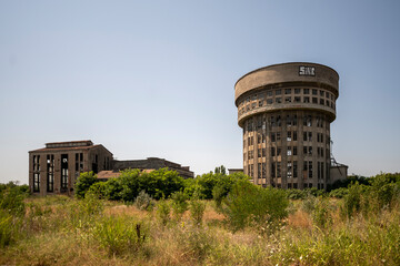 Abandoned distillery tower in Italy &ndash; circular industrial building with glass dome, steel beams, panoramic windows, decaying factory interior, urban exploration, post-industrial architecture