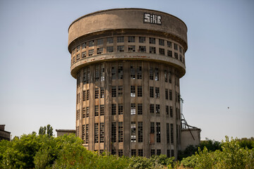 Abandoned distillery tower in Italy – circular industrial building with glass dome, steel beams, panoramic windows, decaying factory interior, urban exploration, post-industrial architecture