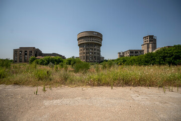 Abandoned distillery tower in Italy – circular industrial building with glass dome, steel beams, panoramic windows, decaying factory interior, urban exploration, post-industrial architecture